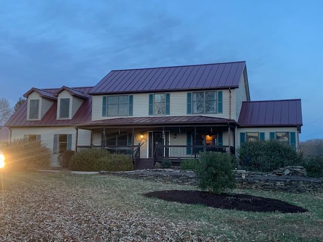 burgundy standing seam metal roof panels on residential home