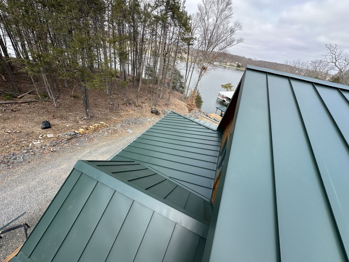 green standing seam metal roofing panels on lake home roof