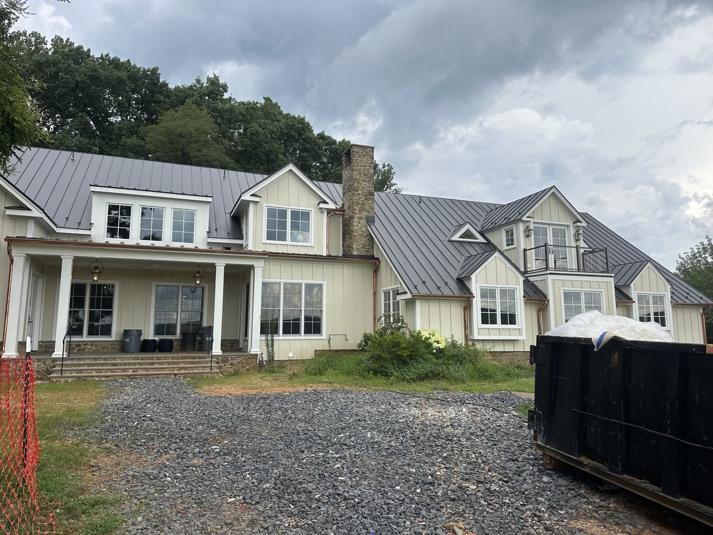 architectural standing seam metal roof installation with stone exterior
