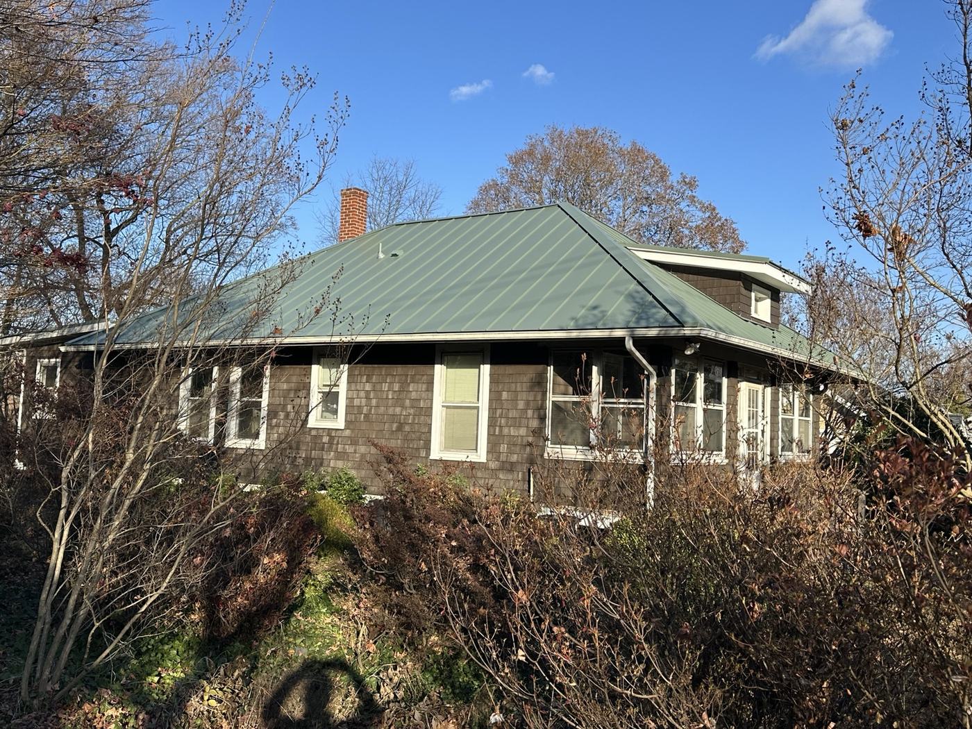 white barn style home with silver standing seam metal roofing panels