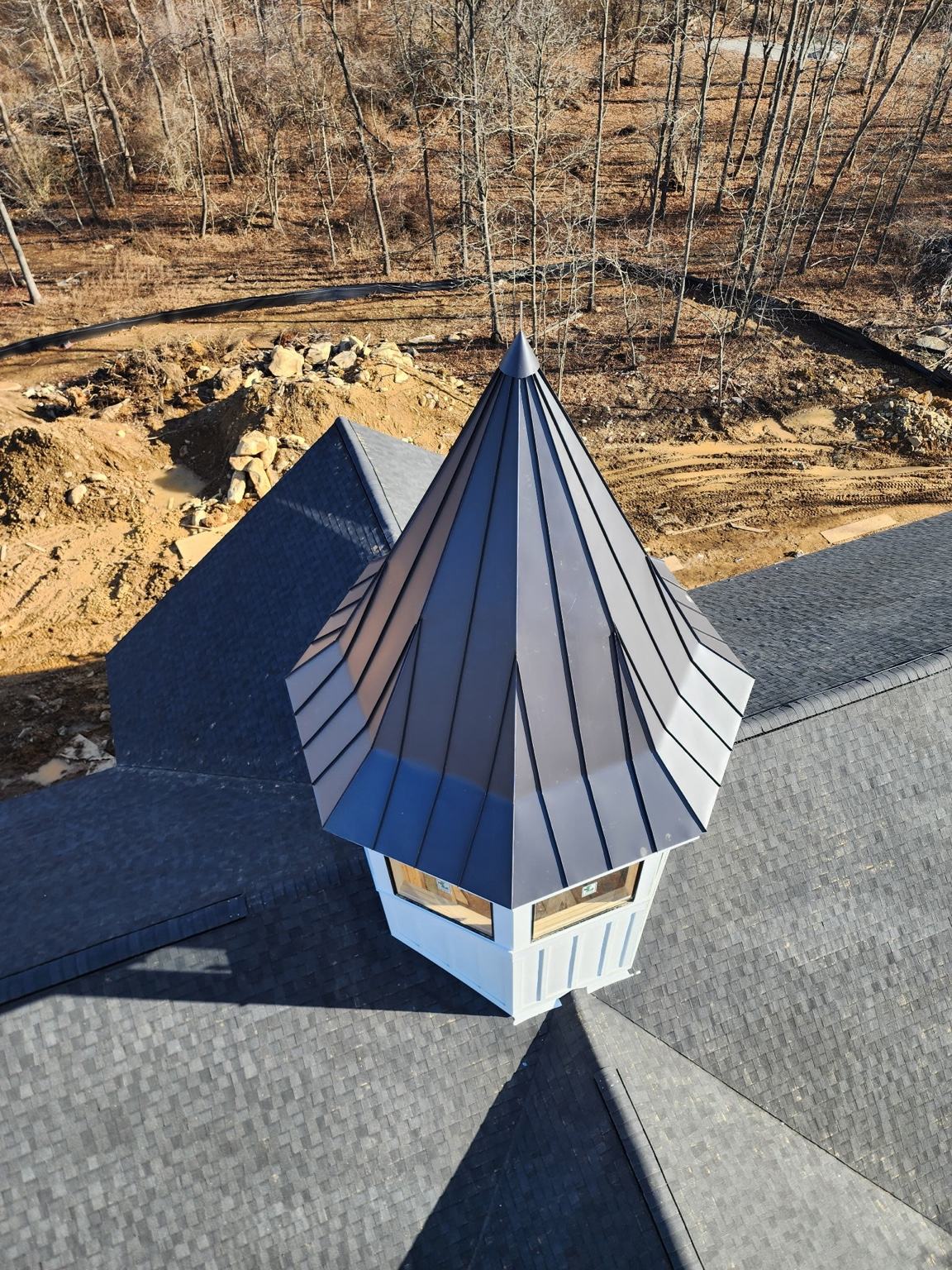 white shed with black standing seam metal roof panels