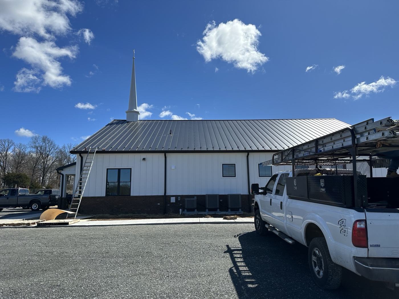 green cut and drop metal roof panels staged at jobsite