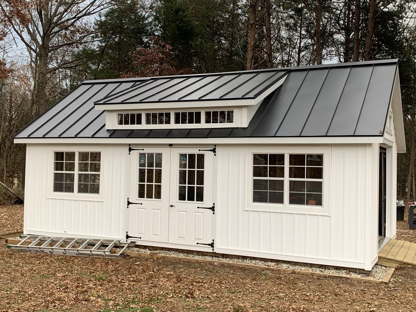 finished white farmhouse with silver standing seam metal roof